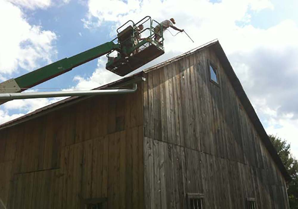 IHS Painting working on a barn